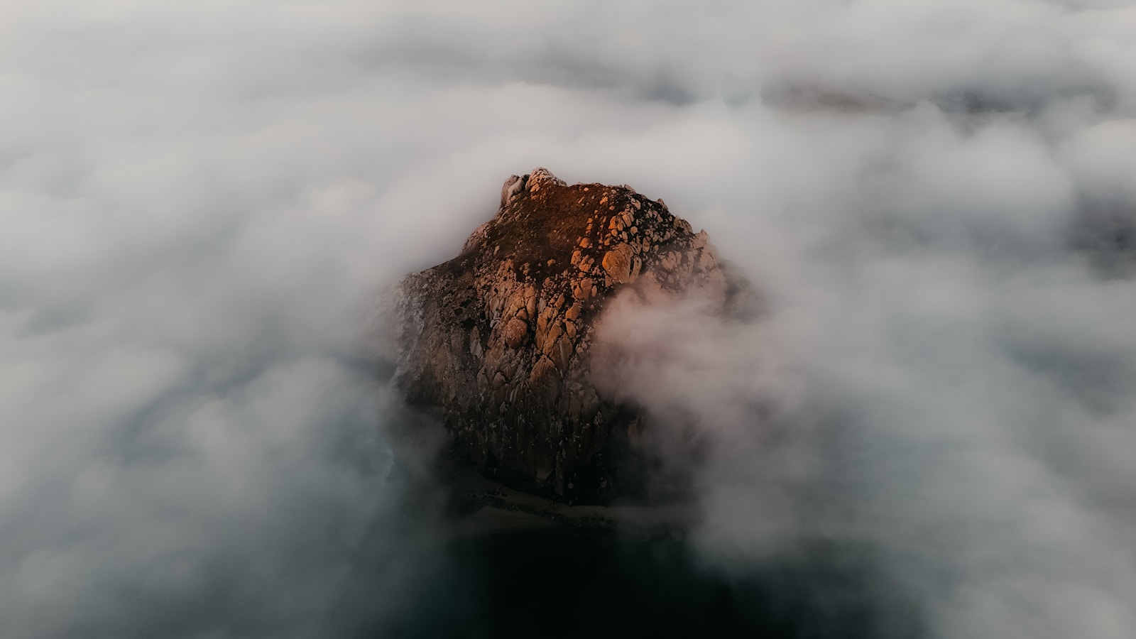 Mountain peak emerging from dense fog